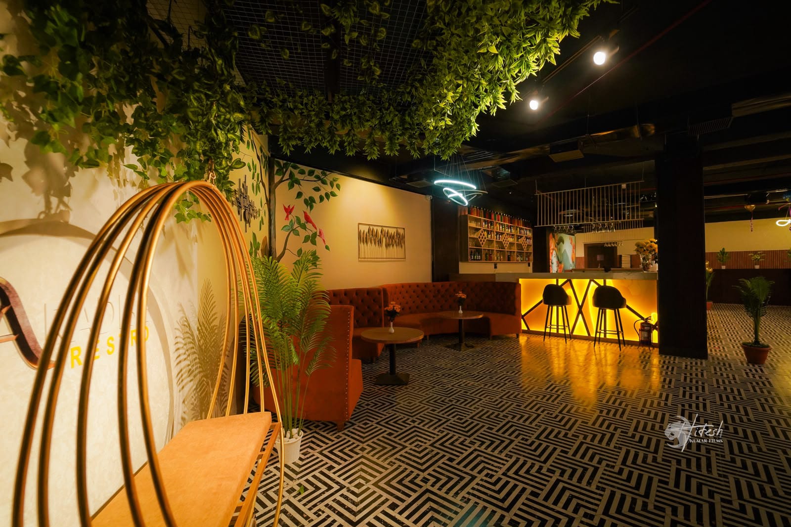 Lounge area at Paradise Restro with geometric floor pattern, bar counter and swing chair